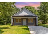 Charming single-story home with gray siding, a covered front porch, and a well-manicured lawn at 925 4Th St, Statesville, NC 28677