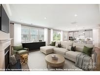 Bright living room featuring a large sectional sofa, fireplace, and large windows with natural light at 9864 Quercus Ln, Huntersville, NC 28078