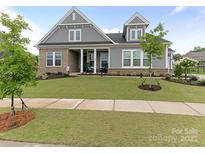 Charming home featuring a mix of brick and gray siding, complemented by a well-maintained lawn at 1005 Willow Bank Ln, Belmont, NC 28012