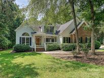 Charming home with a manicured lawn, brick accents and a welcoming front porch lined with manicured shrubs at 12029 Forest Home Dr, Fort Mill, SC 29708