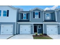 Charming two-story townhouse featuring a one car garage and welcoming front entrance at 1413 Old Rivers Rd, Concord, NC 28027