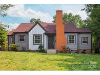 Charming home with a red roof, gray siding, orange chimney, and a well-maintained front lawn at 2628 Clydesdale Ter, Charlotte, NC 28208