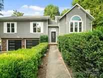 Charming home with a well-manicured lawn, lush landscaping, and welcoming walkway to the front door at 3124 5Th Street Ne Pl, Hickory, NC 28601