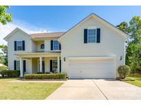 Charming two-story home with a well-manicured lawn, inviting front porch and a two-car garage at 4003 Fine Robe Dr, Indian Trail, NC 28079