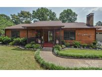 Charming wood home featuring a covered front porch with manicured landscaping and walkway at 4920 Surfwood Dr, Sherrills Ford, NC 28673