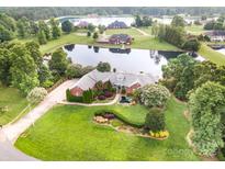 Expansive estate home with a well-manicured lawn, brick exterior and private pond with lake access at 6823 Manatee Dr, Concord, NC 28025