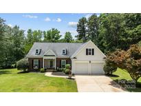 Charming brick and siding home with a well-manicured lawn, two-car garage, and inviting curb appeal at 6908 Beamish Pl, Mint Hill, NC 28227