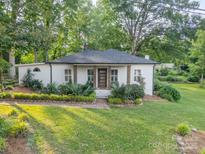 Charming one-story home with brick-lined landscape and a well-manicured lawn nestled among mature trees at 7901 Bud Henderson Rd, Huntersville, NC 28078