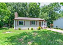Charming single-story home featuring a brick chimney, neutral siding, and well-maintained front lawn at 8019 Walnut Creek Ln, Charlotte, NC 28227