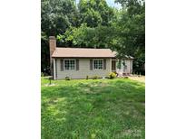 Quaint single-story home with a brick chimney, brown shutters, and a well-manicured lawn at 8019 Walnut Creek Ln, Charlotte, NC 28227