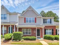 Charming two-story townhome with red brick, red shutters, and manicured landscaping at 10032 Pergola View Ct, Charlotte, NC 28213