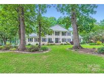 Beautiful two-story white brick home with black shutters and columns, set back on a lush green lawn at 1175 18Th Ne Ave, Hickory, NC 28601