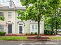 Charming townhome featuring light green siding, bay window, and a black front door, nestled beneath the shade of a mature tree at 13604 Morehouse St, Huntersville, NC 28078