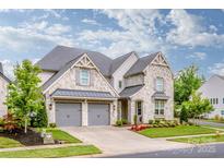 Beautiful stone home with a two-car garage and well-maintained landscaping at 13708 Huntson Park Ln, Huntersville, NC 28078
