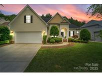 Charming home with a well-manicured lawn, two-car garage, and inviting entrance at dusk at 1653 Shetland Ln, Rock Hill, SC 29730