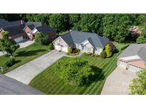 Charming brick home with a well-manicured lawn, lush landscaping, and a long driveway leading to the garage at 179 Browning Dr, Taylorsville, NC 28681