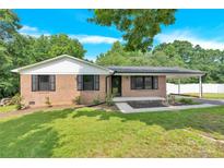 Charming brick home featuring manicured lawn, a covered carport, and a welcoming front entrance at 2323 Brookwood Rd, Lincolnton, NC 28092