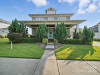 Charming home featuring manicured lawn, welcoming front porch, and a teal front door at 3007 Arsdale Rd, Waxhaw, NC 28173