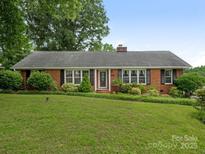 Charming brick ranch home with manicured lawn and mature landscaping at 3408 Oak Tree Trl, Matthews, NC 28105