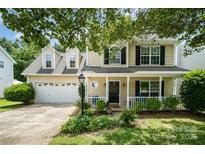 Charming two-story home featuring a welcoming front porch and attached two-car garage with a beautifully landscaped front yard at 3702 Brookstone Trl, Indian Trail, NC 28079