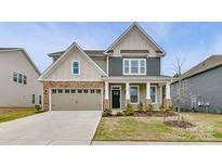 Charming two-story home featuring stone accents, a covered front porch, and a well-manicured lawn at 5635 Agora Ct, Lancaster, SC 29720