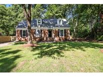 Charming brick home with dormer windows and a well-maintained front yard surrounded by mature trees at 6127 Eagle Peak Dr, Charlotte, NC 28214