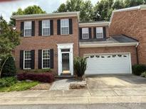 Traditional brick home with black shutters, a two-car garage, and well-maintained landscaping at 9177 Bonnie Briar Cir, Charlotte, NC 28277