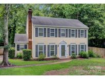 Charming two-story home with a brick chimney and manicured landscaping, perfect for Gathering living at 1006 Covewood Ct, Charlotte, NC 28270