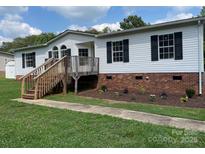 Charming home featuring black shutters and a wooden porch in a well-manicured lawn at 1201 Forest Ridge Rd, Bessemer City, NC 28016