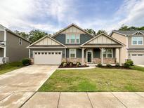 Charming single-Gathering home with a well-manicured lawn, a two-car garage, and stone accents at 1211 Calder Dr, Indian Trail, NC 28079