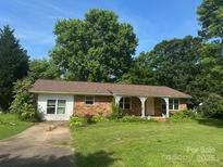 Charming brick ranch home with a well-manicured lawn and mature trees, creating a peaceful and inviting curb appeal at 1421 N Post Rd, Shelby, NC 28150