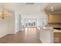 Bright living room featuring hardwood floors, a cozy fireplace, and large windows with outdoor views at 14347 San Paolo Ln, Charlotte, NC 28277