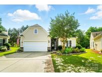 Charming home featuring a two-car garage, manicured lawn, and beautiful landscaping with a stone-accented facade at 15116 Legend Oaks Ct, Fort Mill, SC 29707