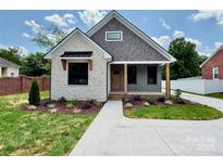 Charming home with stone and siding exterior, landscaped front yard, and inviting covered porch at 1721 S New Hope Rd, Gastonia, NC 28054