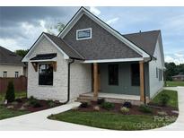Charming home with stone and siding, landscaped yard, covered porch with natural wood pillars, and new construction appeal at 1721 S New Hope Rd, Gastonia, NC 28054