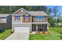 Charming two-story home with a blend of stone and siding, featuring an attached garage and well-manicured lawn at 2527 Linhay Dr, Charlotte, NC 28216