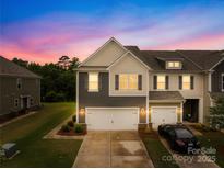 Charming townhome with a two-car garage and manicured lawn under a colorful sunset at 2717 Aubrey St, Monroe, NC 28110