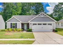 Charming one-story home with grey siding, stone accents, manicured lawn, and a two-car garage at 4511 Hunton Dale Nw Rd, Concord, NC 28027