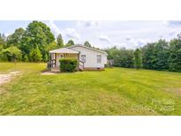 Charming single-story home with a well-maintained lawn, mature trees, and inviting front porch at 4630 Irish Potato Rd, Kannapolis, NC 28083