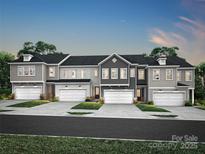 A row of modern townhomes, each featuring a private garage and manicured front lawn, under a twilight sky at 507 Webster Ln, Cramerton, NC 28032