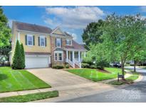 Charming two-story home featuring a well-manicured lawn, attached garage and a stone and yellow siding facade at 8044 Hawk Crest Ct, Charlotte, NC 28270