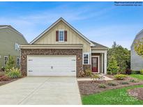 Charming single-Gathering home featuring a brick-accented facade, two-car garage, and a well-manicured lawn at 8450 Norman Forest Rd, Lancaster, SC 29720