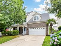 Charming two-story home features a brick facade, well-manicured lawn, and a spacious two-car garage at 1016 Yellow Daisy Dr, Matthews, NC 28104