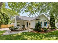 Charming single-story home featuring a cozy front porch with seating and lush landscaping at 10621 Glenmac Rd, Charlotte, NC 28215