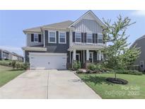 Beautiful two-story home featuring a two-car garage, and a well-manicured lawn at 151 Outrigger Ln, Troutman, NC 28166
