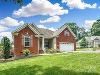 Charming brick home featuring a well-manicured lawn, attached two-car garage, and welcoming front entrance at 1625 Damascus Cir, Conover, NC 28613