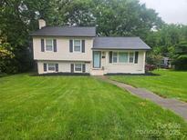 Charming home with manicured lawn, fresh landscaping, and a welcoming light blue front door at 1645 Brookdale Ave, Charlotte, NC 28210