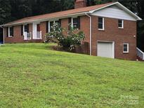 Two-story brick home with a well-manicured lawn and mature landscaping offers great curb appeal at 1660 Songwood Rd, Concord, NC 28025