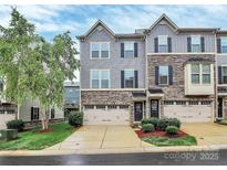 Charming townhome with stone accents, gray siding, attached garages and manicured landscaping at 1723 Town Oak Ln, Charlotte, NC 28205