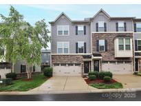 Charming townhome featuring a combination of stone and gray wood siding and private garage at 1723 Town Oak Ln, Charlotte, NC 28205